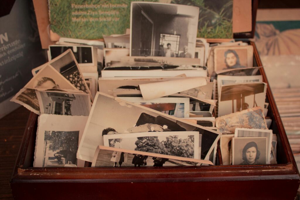 Photo by Miray Bostancı A collection of old black-and-white photographs stored in a vintage wooden box, evoking nostalgia.